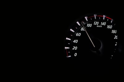 Speedometer showing over 80 mph at night