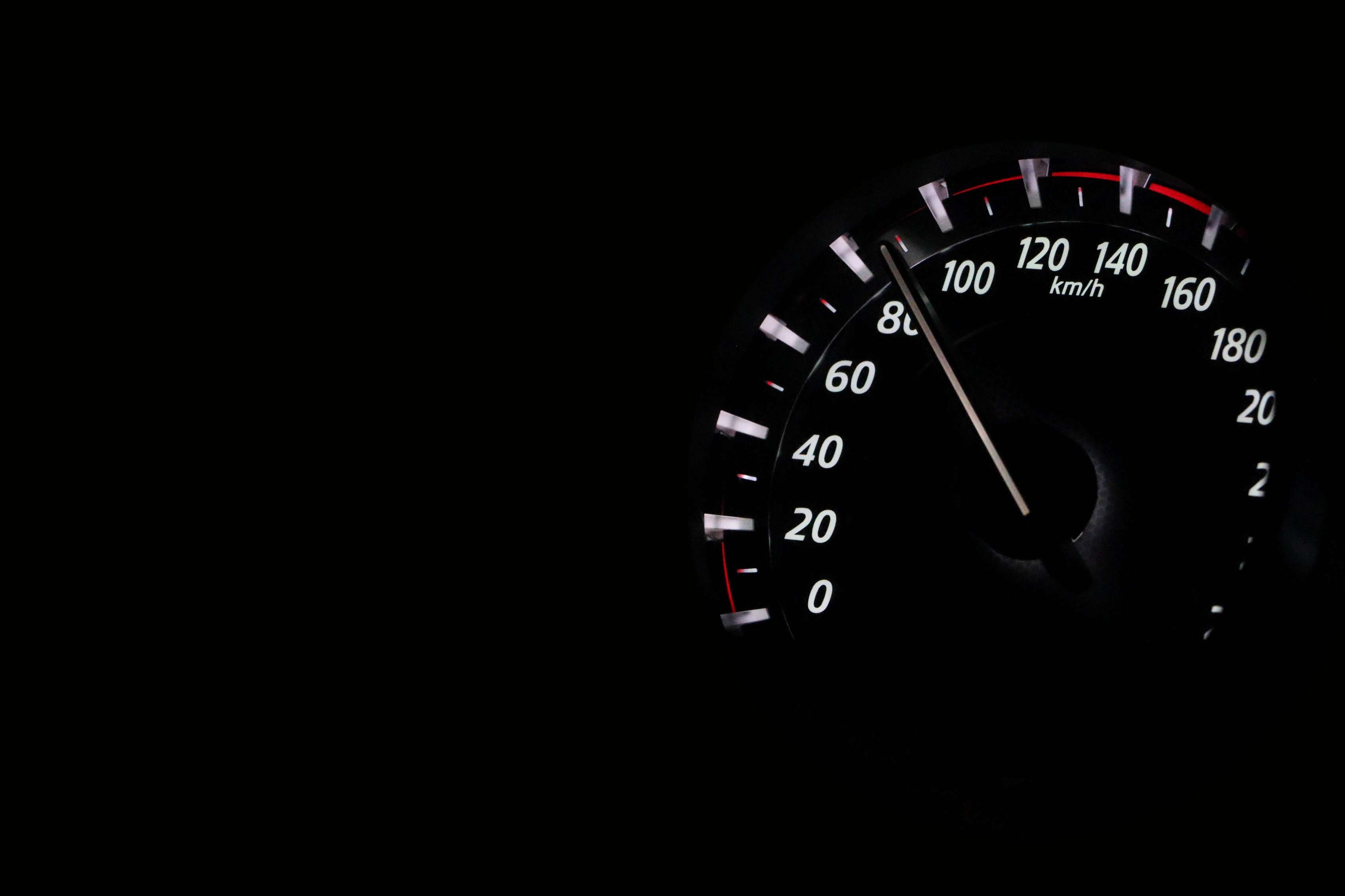 Speedometer at night showing over 80 mph
