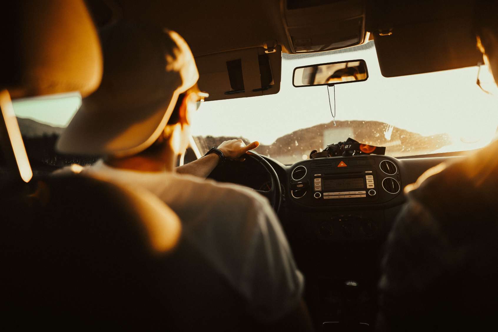 young man wearing backwards baseball cap driving car