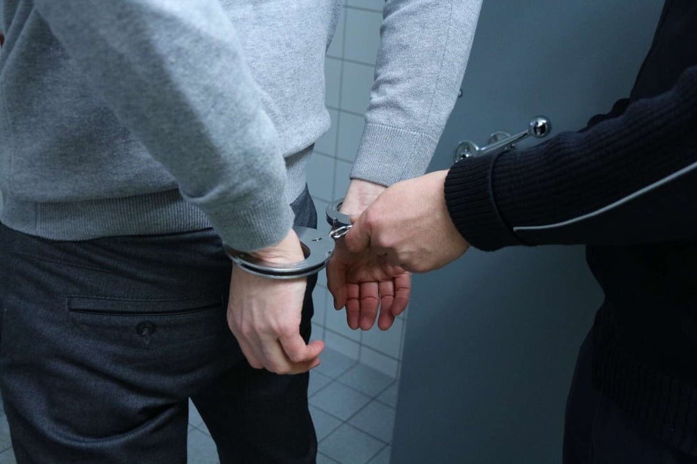 police officer putting handcuffs on offender in grey sweatshirt